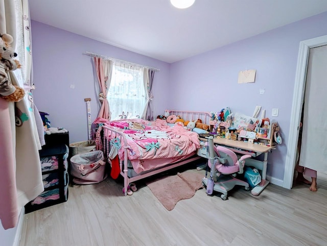 bedroom with baseboards and wood finished floors