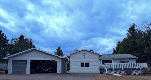 view of front of property featuring a garage, a wooden deck, and an outdoor structure