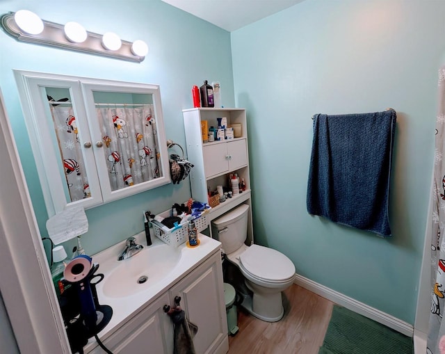 full bathroom with toilet, curtained shower, wood finished floors, baseboards, and vanity