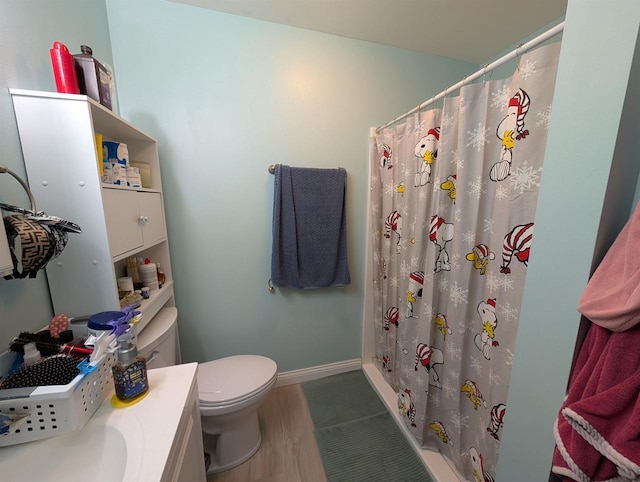 full bath featuring vanity, wood finished floors, baseboards, curtained shower, and toilet