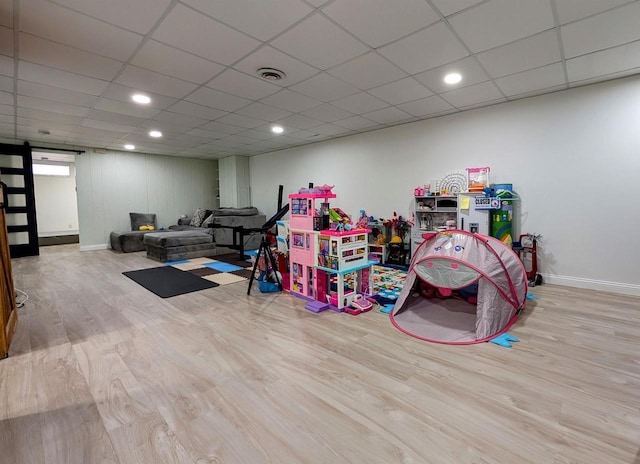 rec room featuring visible vents, baseboards, a drop ceiling, recessed lighting, and wood finished floors