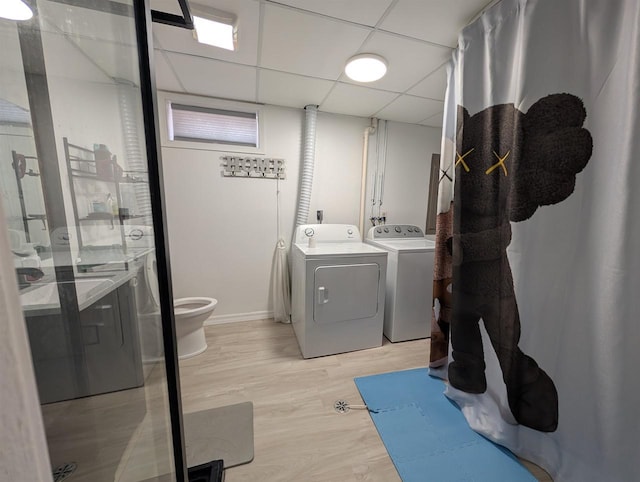 laundry room with light wood-style flooring, washing machine and dryer, and laundry area