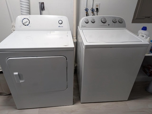 laundry room featuring electric panel and washer and clothes dryer