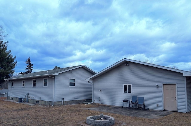 back of house featuring central air condition unit and an outdoor fire pit