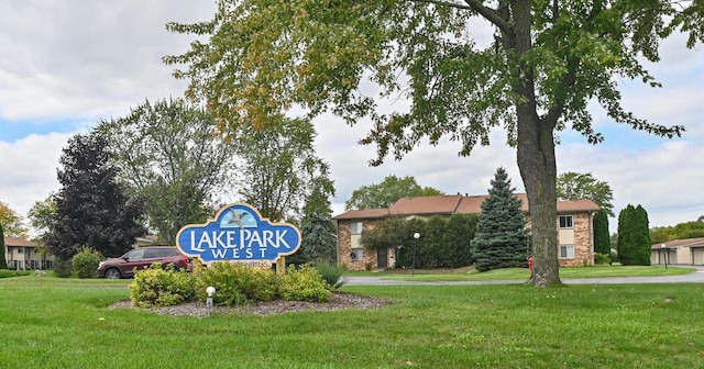 community / neighborhood sign featuring a yard