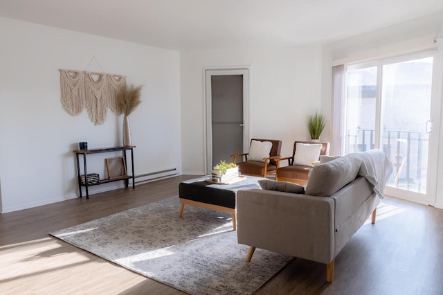 living room featuring baseboard heating, baseboards, and wood finished floors