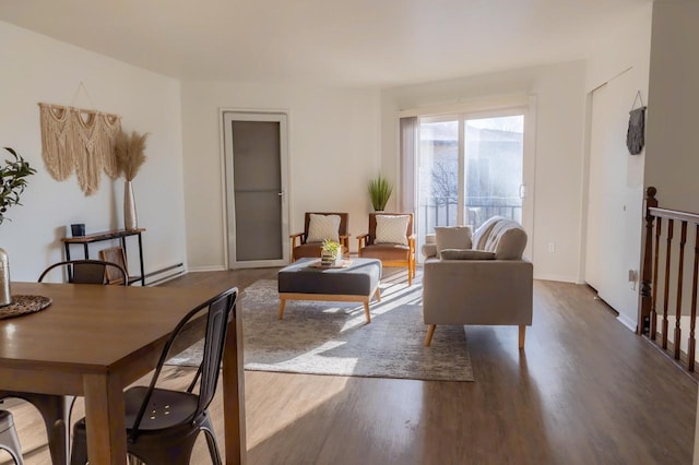 living room with a baseboard heating unit, baseboards, and wood finished floors