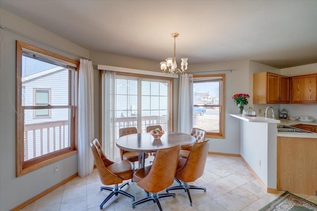 dining room featuring light tile patterned floors, baseboards, and a notable chandelier