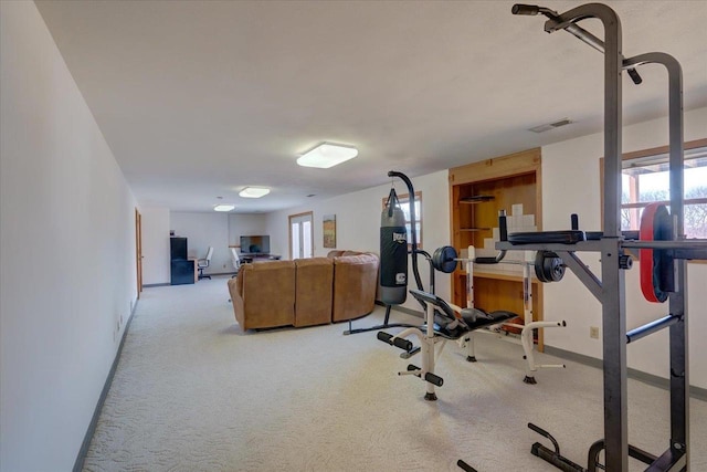 exercise room featuring visible vents, baseboards, and light colored carpet