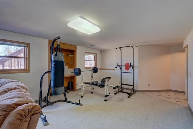 exercise room featuring baseboards and carpet flooring