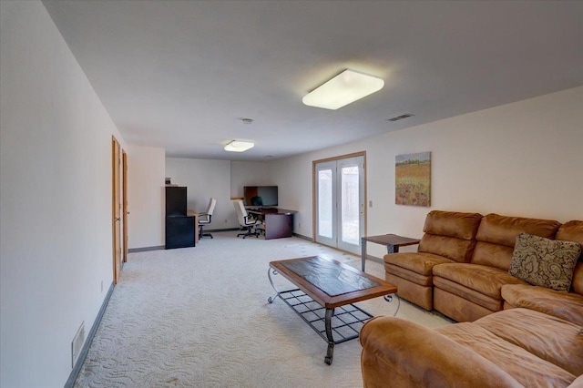 living area with light carpet, visible vents, french doors, and baseboards