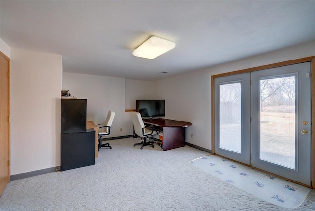 office area featuring baseboards and light carpet