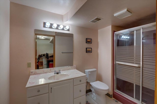 bathroom featuring vanity, a shower stall, toilet, and visible vents