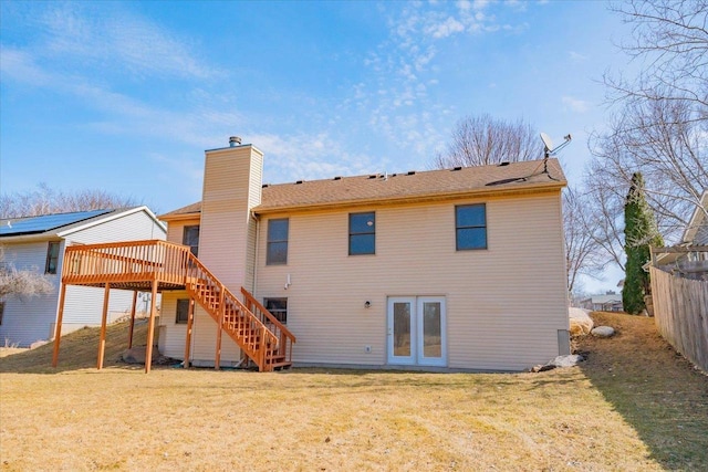 back of house with a lawn, a deck, fence, stairway, and a chimney