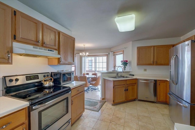 kitchen with under cabinet range hood, stainless steel appliances, light countertops, and a sink