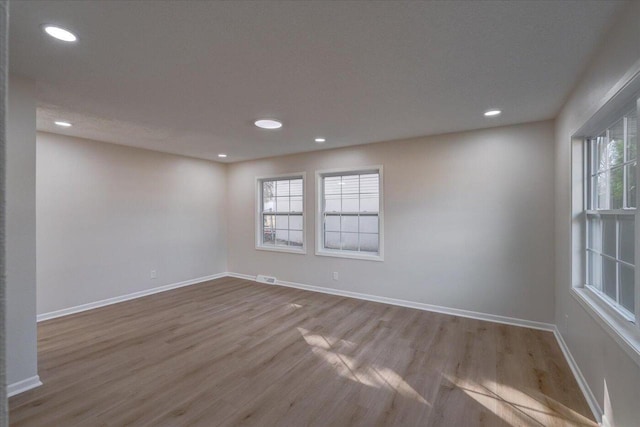 empty room with recessed lighting, baseboards, and wood finished floors