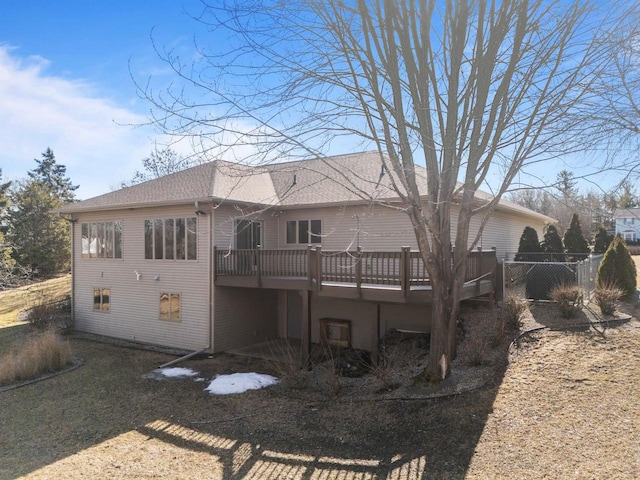 back of house with a deck, fence, and a shingled roof