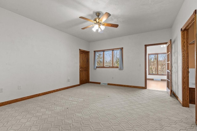 unfurnished room featuring visible vents, baseboards, and a ceiling fan