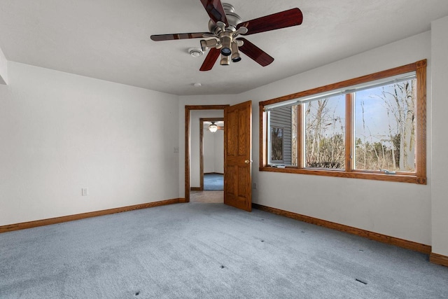 empty room featuring baseboards and light carpet