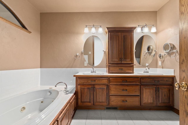 bathroom featuring double vanity, a whirlpool tub, tile patterned floors, and a sink