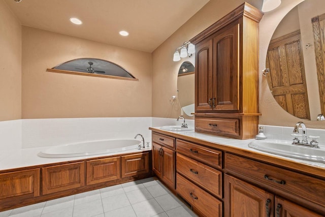 bathroom with tile patterned flooring, double vanity, a garden tub, and a sink