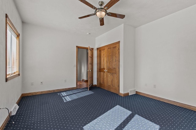 unfurnished room with visible vents, baseboards, carpet, and a ceiling fan