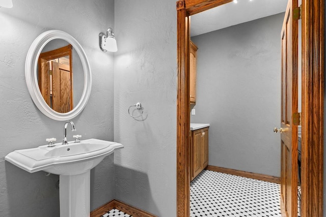 bathroom featuring baseboards and a textured wall