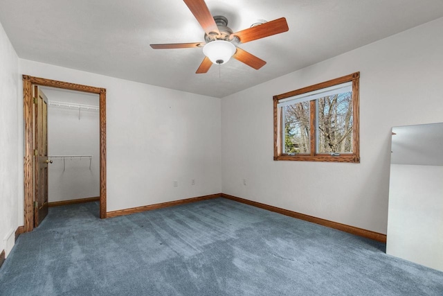 unfurnished bedroom with baseboards, carpet floors, ceiling fan, a spacious closet, and a closet