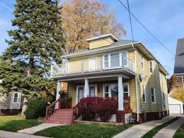 american foursquare style home with an outbuilding, a balcony, and covered porch