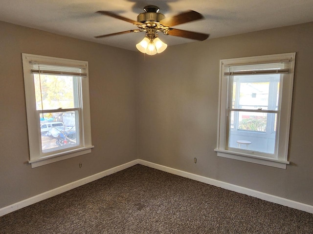 unfurnished room featuring a ceiling fan, baseboards, and dark colored carpet