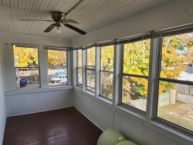 unfurnished sunroom featuring wooden ceiling and ceiling fan