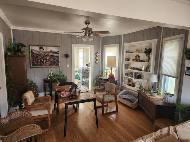 living room with ceiling fan, wood-type flooring, and ornamental molding