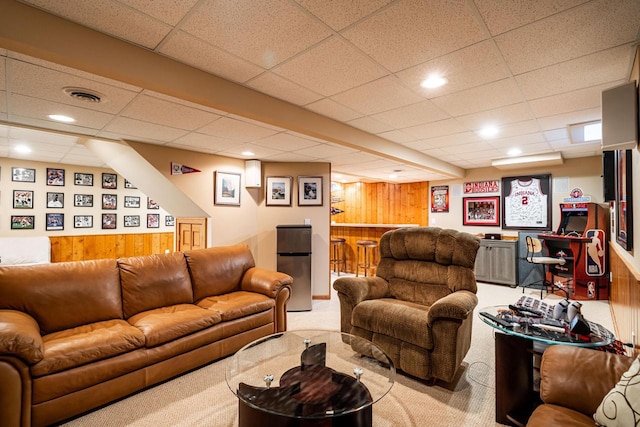 living area featuring recessed lighting, visible vents, carpet floors, and wooden walls