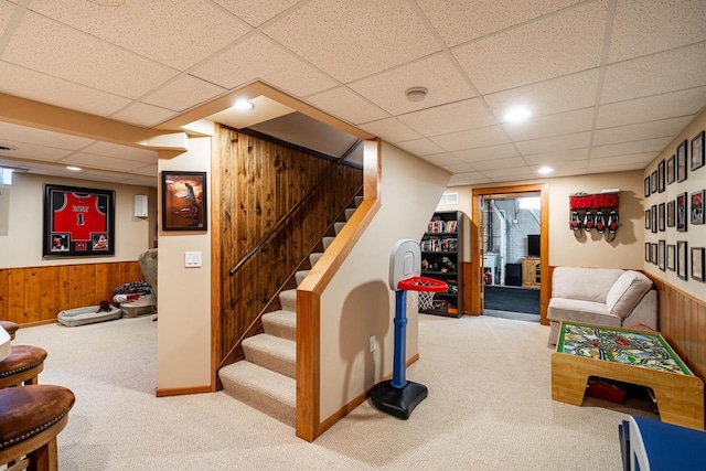 interior space featuring wooden walls, a paneled ceiling, a wainscoted wall, and carpet floors