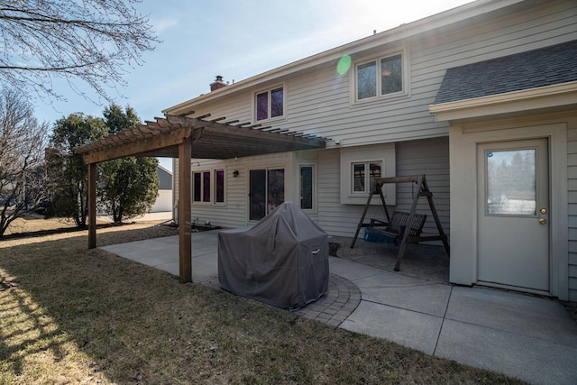 rear view of property featuring roof with shingles, a lawn, a chimney, a patio area, and a pergola