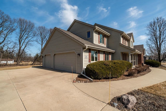 view of property exterior featuring a garage, driveway, and a shingled roof