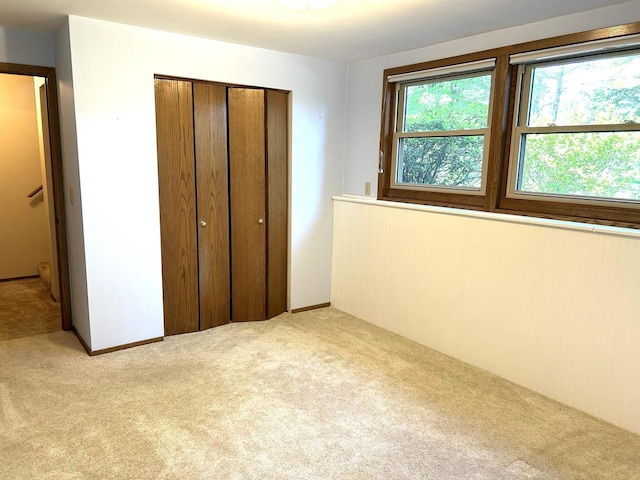 unfurnished bedroom with a closet and light carpet