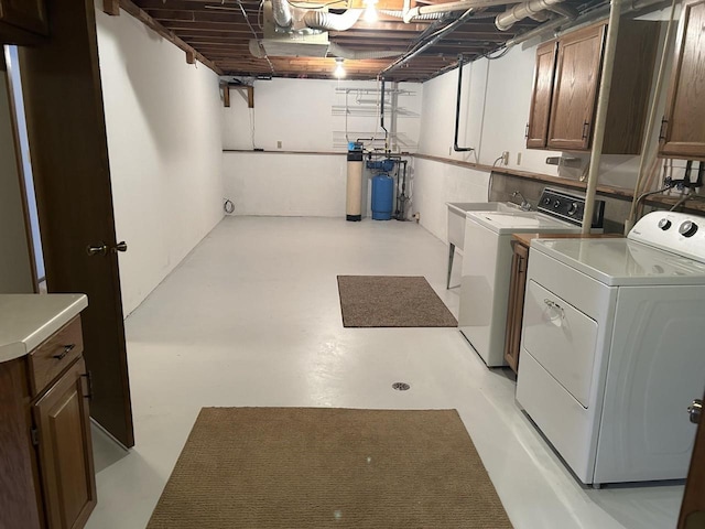 laundry area with cabinet space, independent washer and dryer, and a sink