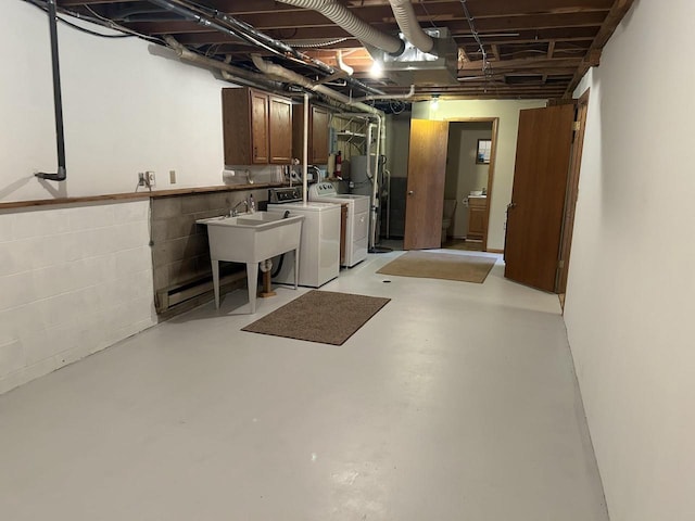 unfinished basement with water heater, washing machine and dryer, concrete block wall, and a sink