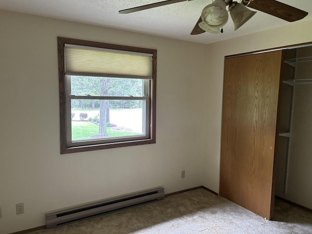 unfurnished bedroom with ceiling fan, carpet, a closet, a textured ceiling, and a baseboard radiator