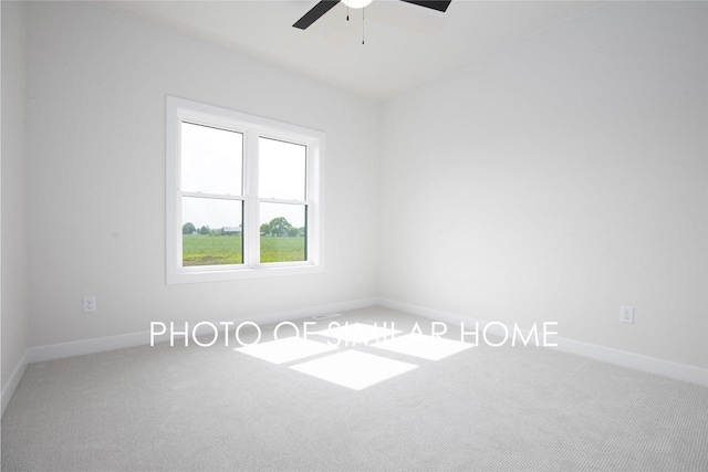 carpeted spare room featuring baseboards and ceiling fan