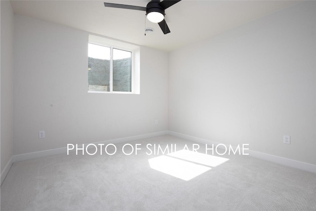 carpeted spare room featuring baseboards and ceiling fan