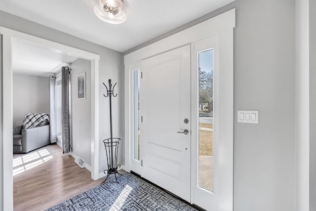 entryway featuring baseboards and wood finished floors