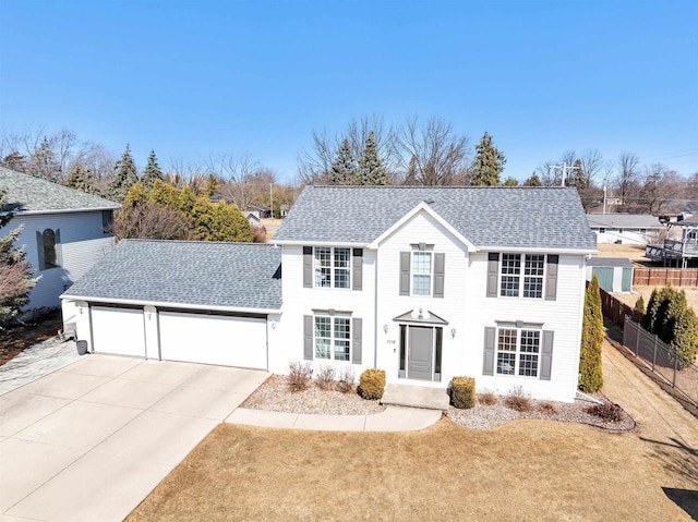 view of front of property with concrete driveway, an attached garage, fence, and roof with shingles