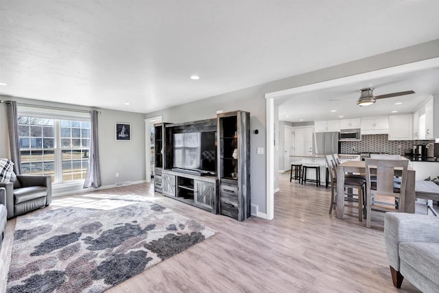 living area with visible vents, baseboards, recessed lighting, light wood-style floors, and a ceiling fan