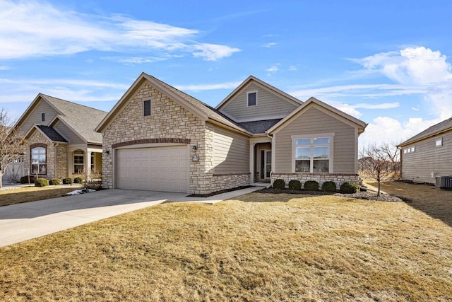 view of front of property featuring central air condition unit, a front lawn, driveway, stone siding, and a garage