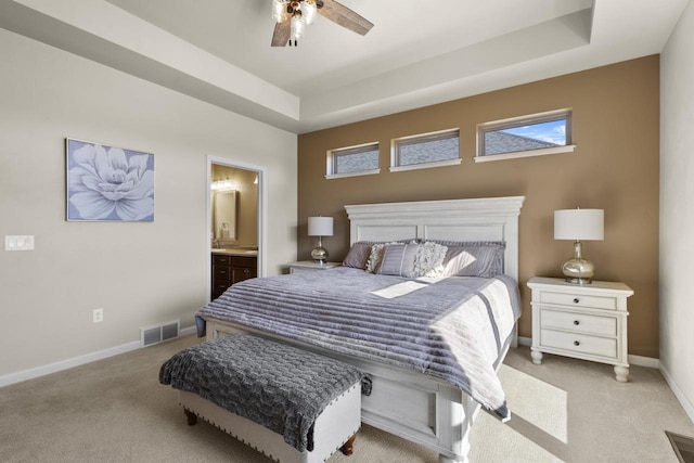 bedroom with light colored carpet, a raised ceiling, baseboards, and visible vents