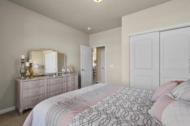 carpeted bedroom featuring baseboards and a closet