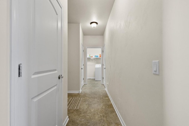 corridor with baseboards and washer / dryer