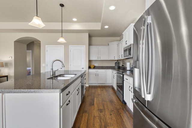 kitchen featuring a sink, dark wood finished floors, recessed lighting, arched walkways, and appliances with stainless steel finishes